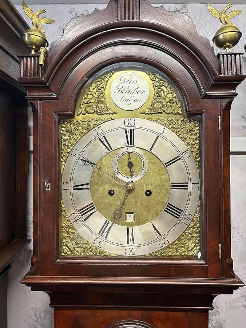 Antique Grandfather Clock with Brass Details Antique grandfather clock featuring a brass dial and Roman numerals, housed in a polished wooden cas.