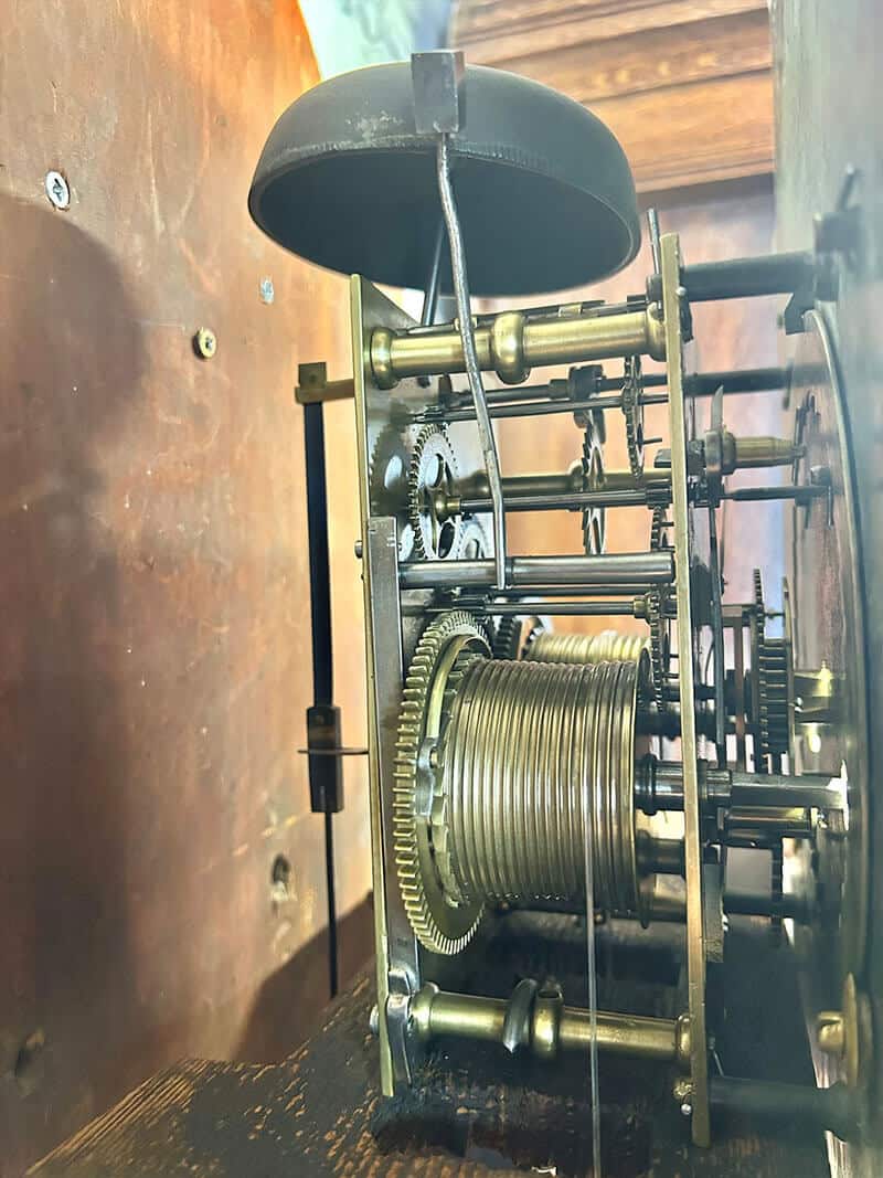 Vintage clock movement mechanism with brass gears and components. Antique clock movement showcasing intricate brass gears and mechanical parts.