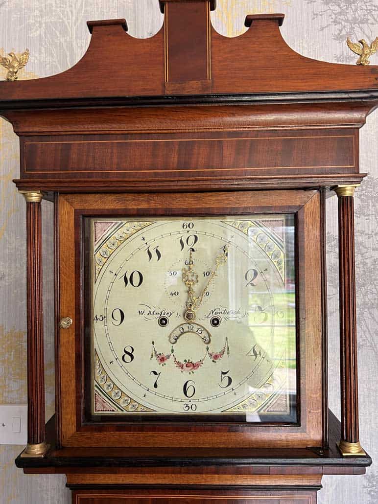 Vintage wooden grandfather clock with ornate design and brass accents. Antique wooden grandfather clock with brass details and classic design.